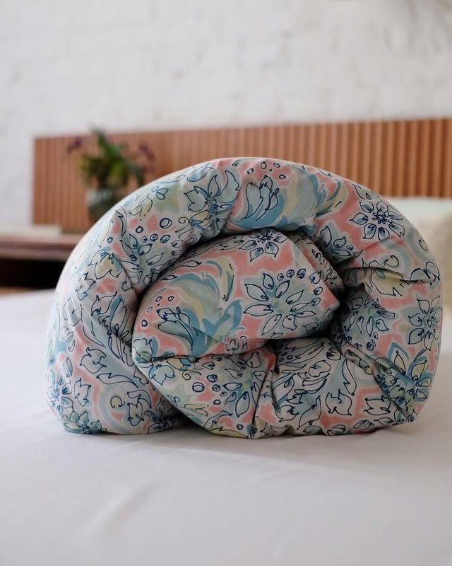 Edredom floral enrolado sobre a cama