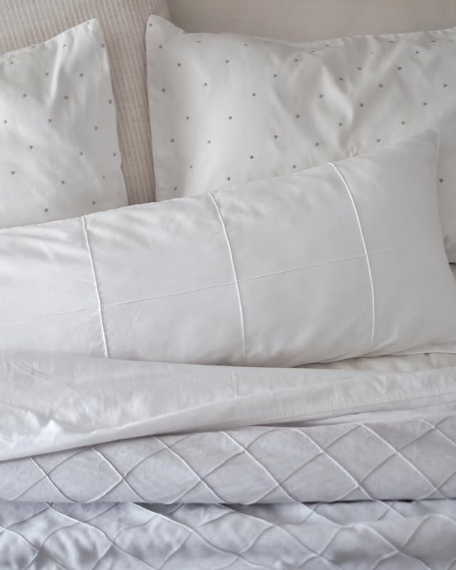 Roupa de cama branca com poás