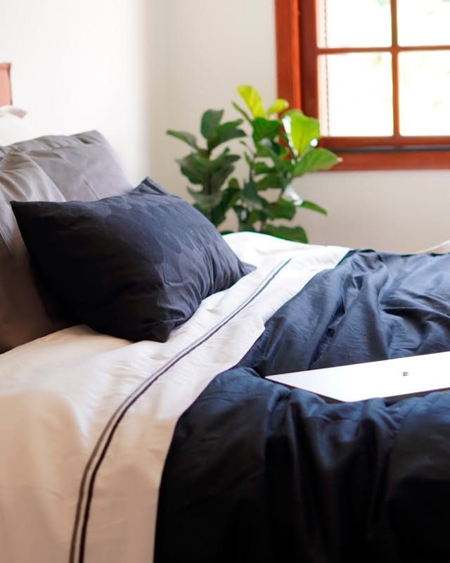 Cama marinho e branca à janela